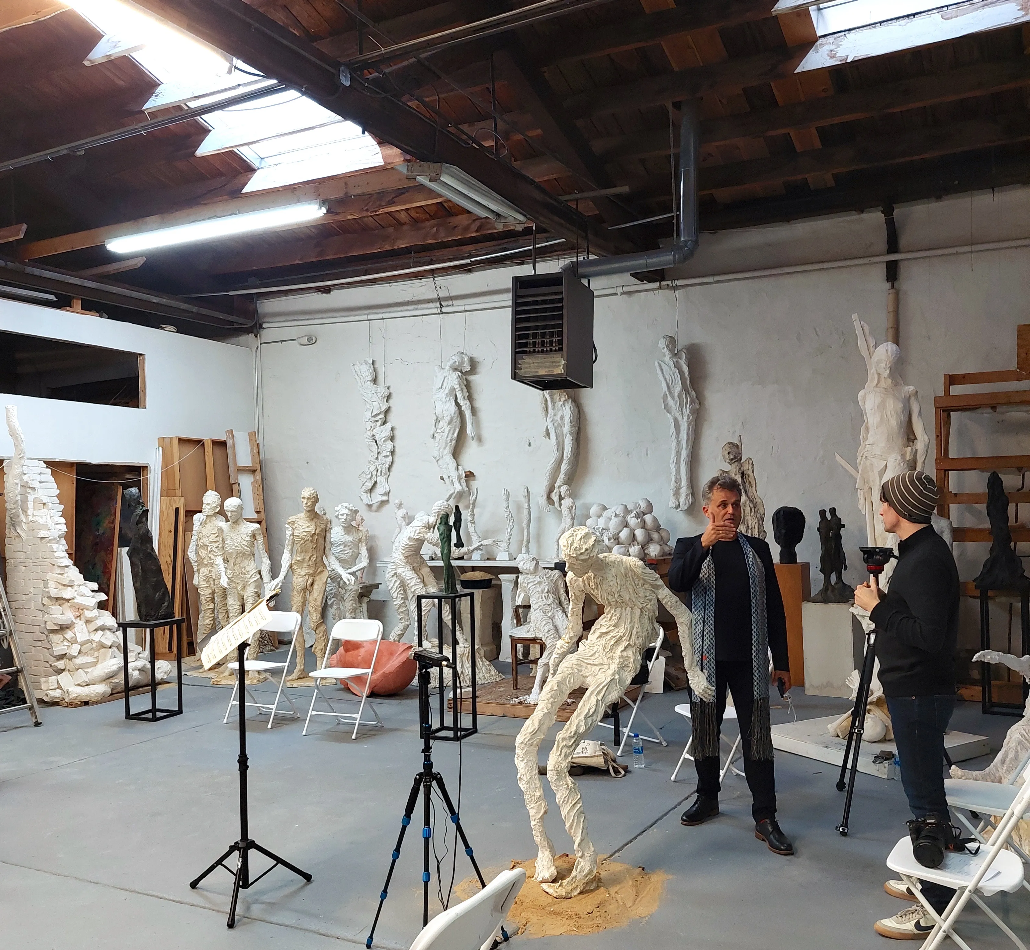 Tim Holt with Peter in a sculpture studio, surrounded by plaster figures